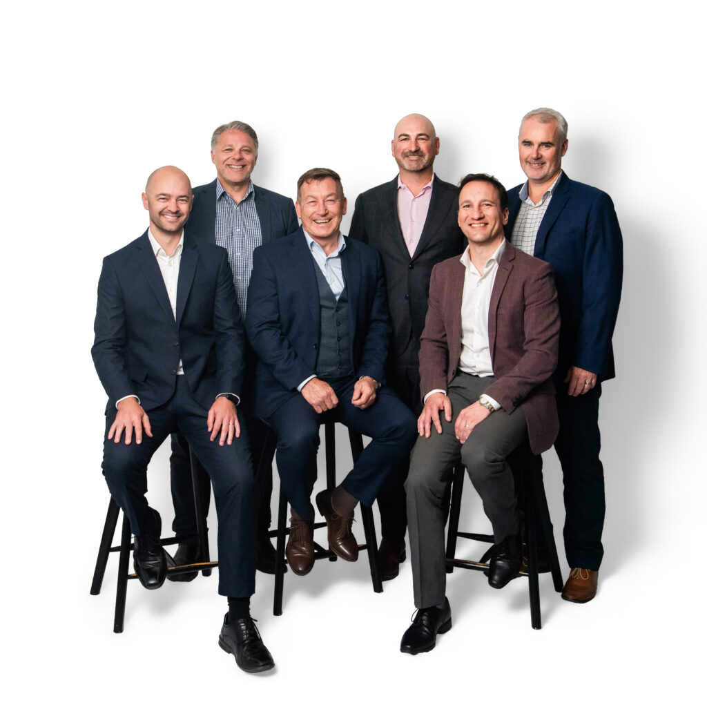 Securinvest leadership team of six men in business suits, three seated on stools and three standing behind, against a white studio backdrop.
